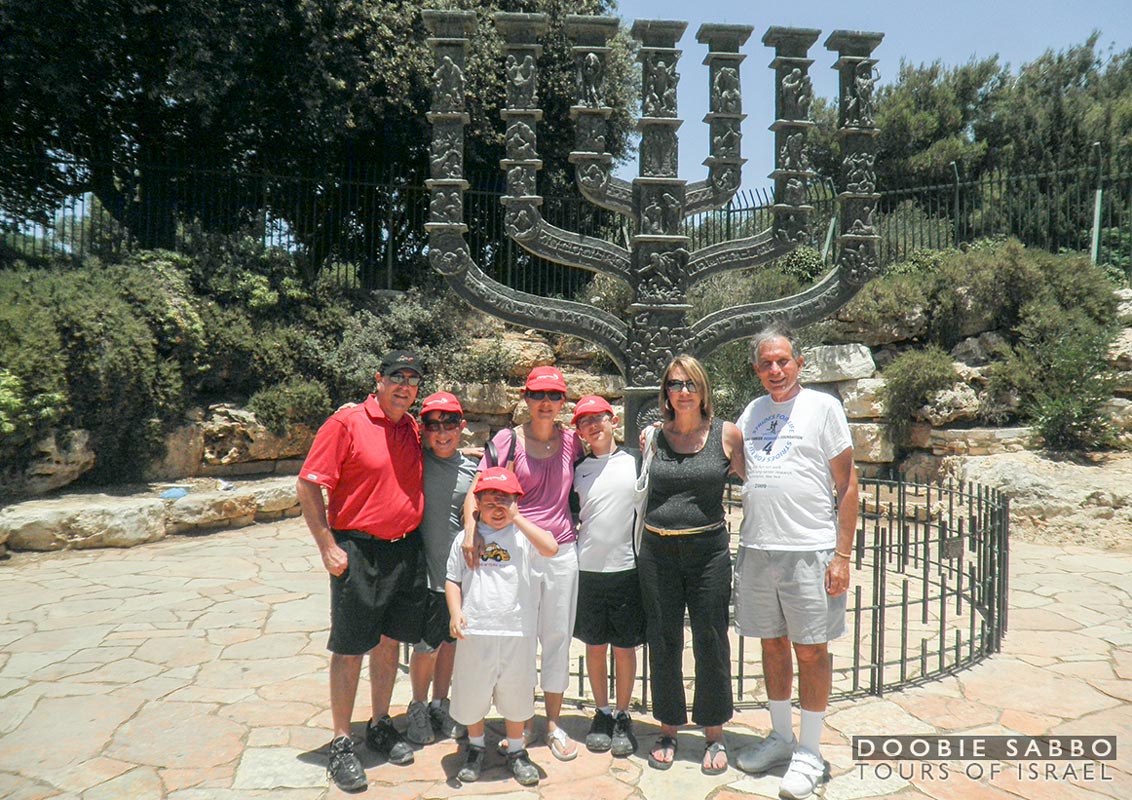 Family tour group in front of the Knesset Menorah.